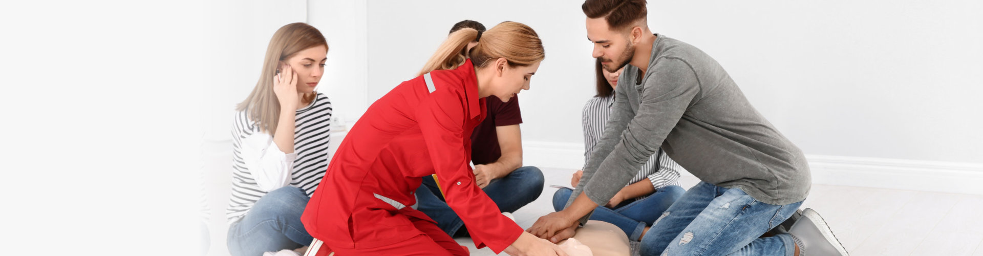 people with instructor practicing cpr on mannequin